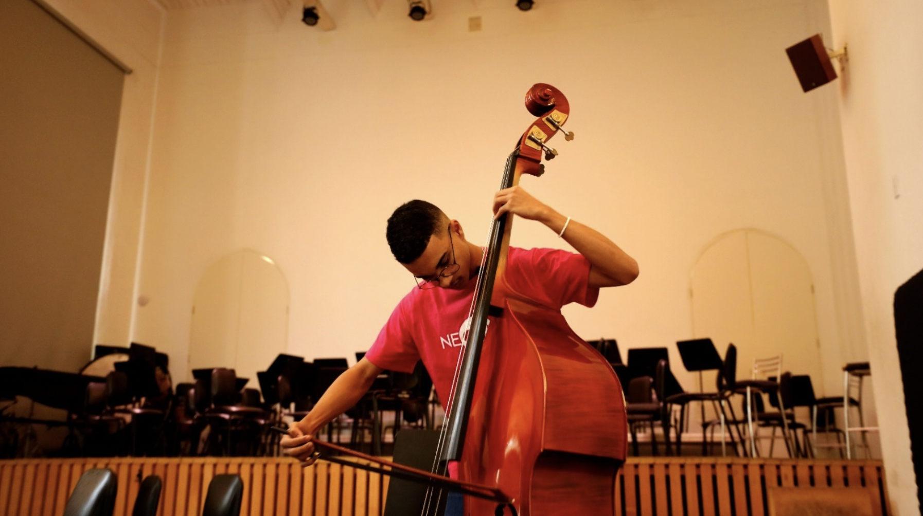 Profissional do NEOJIBA tocando instrumento musical 